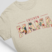 Chicken Mama retro design t-shirt in beige color, lying flat on a neutral background. Features bold floral lettering on a Bella+Canvas 3001 shirt.