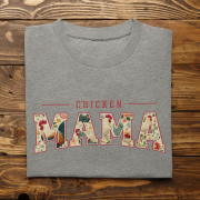 Chicken Mama retro design t-shirt in gray, folded neatly and displayed on a rustic wooden surface. Floral lettering adds charm to the Bella+Canvas 3001 shirt.