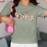 Woman wearing a sage green Chicken Mama retro design t-shirt paired with white shorts and a pink purse. Floral lettering adds vibrant detail to the Bella+Canvas 3001 shirt.